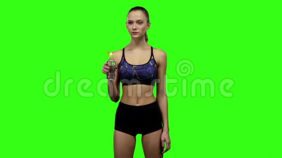 穿运动服的女孩从瓶子里喝水慢动作绿色屏幕视频的预览图