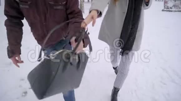 男人在公园里偷了一个女孩的包抢劫犯罪概念在冬天公园里散步的女人小偷抢劫犯视频的预览图