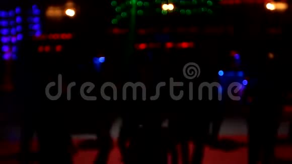 人们在夜总会里跳舞玩得开心放松背景模糊光的闪光舞池上美丽模糊的灯光视频的预览图