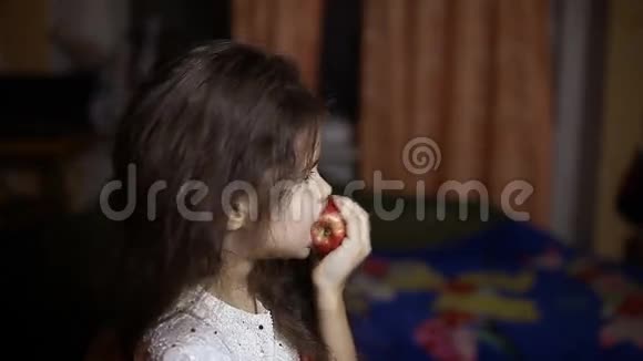 女孩晚上坐在房间里吃苹果视频的预览图