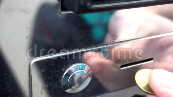 顾客将硬币插入老式自动售货机的投币口视频的预览图