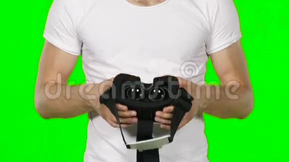 男性手拿虚拟现实耳机绿色屏幕慢动作视频的预览图