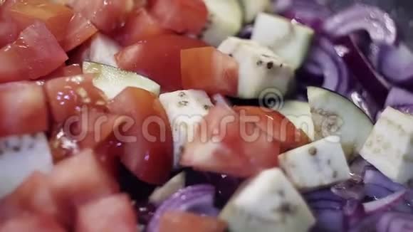 特写切碎的蔬菜西红柿洋葱和茄子正在油炸视频的预览图