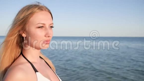 海滩上的肖像女孩望着远方美丽的女人风视频的预览图
