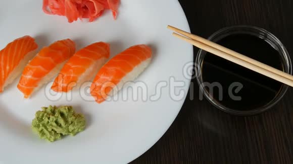 四个大寿司和一块鲑鱼躺在一个大平板上相机放大视频的预览图