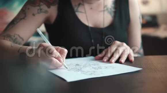 纹身师在一个家庭工作室里用纸做纹身素描视频的预览图