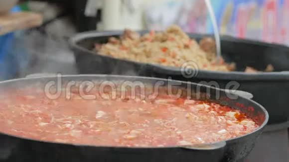 为乞丐提供热汤铸铁锅中的食物志愿者在木炉上准备饭菜难民营视频的预览图