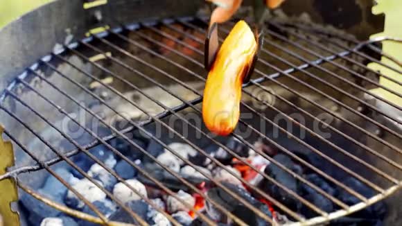 夏季烧烤时用火钳在热烤架上烤汁香肠视频的预览图