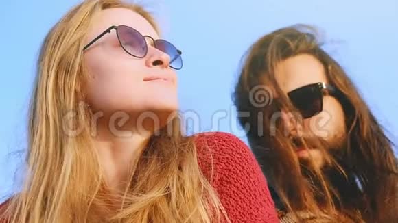 太阳眼镜的年轻夫妇在日出时拥抱亲吻视频的预览图