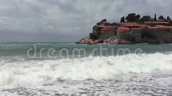 巨大的海浪淹没了海岸背景是一个宏伟的岛屿有古老的房子和瓷砖屋顶视频的预览图