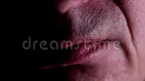 男人的嘴半张嘴在黑暗中特写视频的预览图