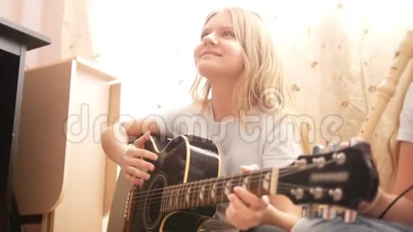 两名女青少年在家演奏乐器吉他和长笛视频的预览图