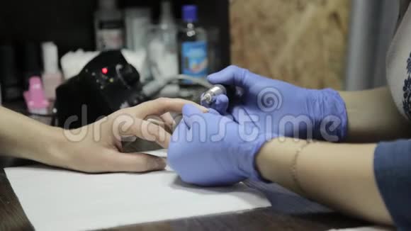 美甲师在美甲沙龙为女性客户做专业的凝胶抛光指甲女性留指甲视频的预览图