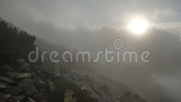 岩石高高的山顶上有快速移动的云雨后日落平稳运动视频的预览图