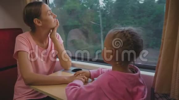 一家人在亚洲的火车旅行中消磨时间寻找窗口交谈视频的预览图