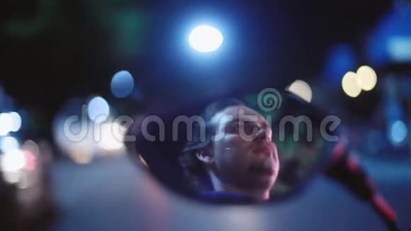 年轻英俊的极端男子驾驶摩托车在夜晚反射在镜子上模糊的薄光夜美丽视频的预览图
