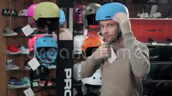 在极限运动商店购买滑雪板前男士选择头盔视频的预览图