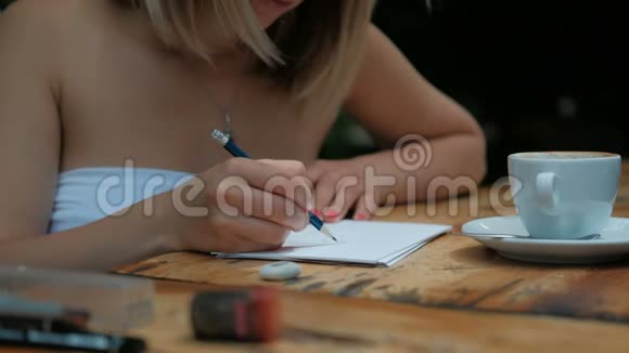 拿着一杯咖啡的女人在纸上画了一幅铅笔素描视频的预览图