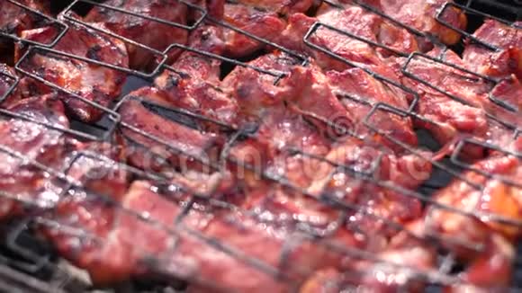 露天烧烤多汁的肉在烤架上慢动作60fps烧木头和生肉在煤上煮熟热辣视频的预览图