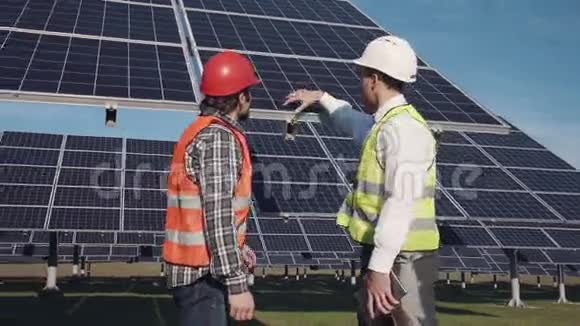 技术人员在外面讨论太阳能电池板阵列视频的预览图