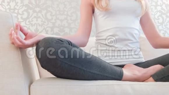 在沙发上做瑜伽的漂亮女士视频的预览图