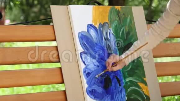 女孩在画布上涂上油彩画出美丽的花朵成人女画家时间推移视频的预览图