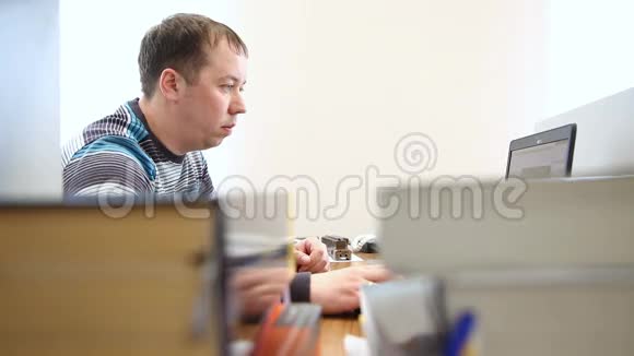 男人在电脑前以书刊为背景工作视频的预览图