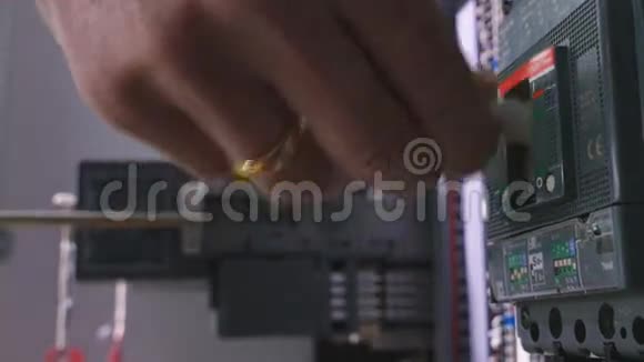 工厂电工工程师用螺丝刀将特种设备安装到保险丝盒中视频的预览图