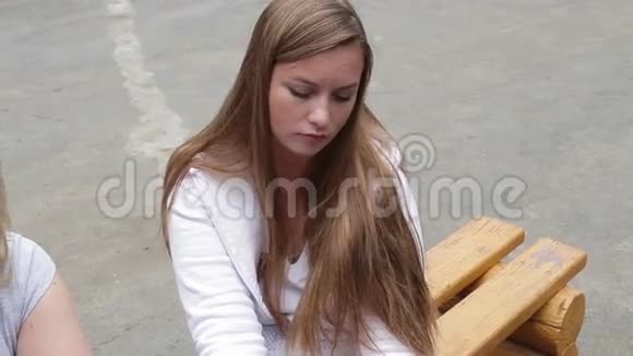 伤心的女孩坐在街上的长凳上视频的预览图