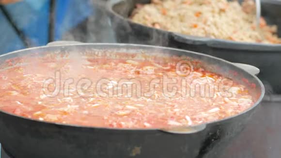 铸铁锅中的食物志愿者在木炉上准备饭菜难民营为乞丐准备热汤视频的预览图