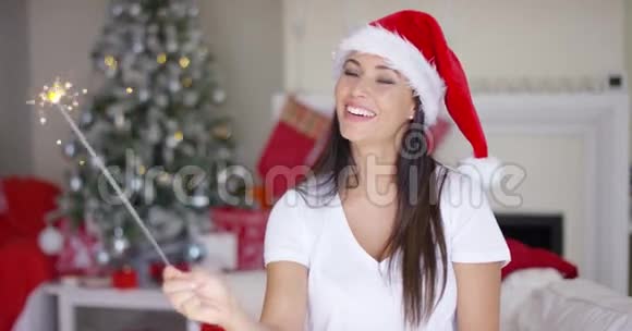 笑着的年轻女子燃烧着圣诞的火花视频的预览图