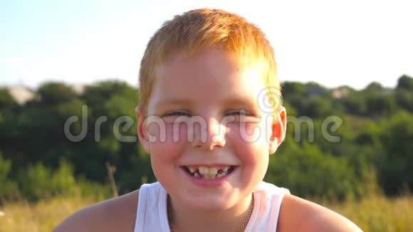 有雀斑的快乐红发男孩的肖像笑在户外可爱英俊的宝宝带着喜悦的心情看着镜头视频的预览图