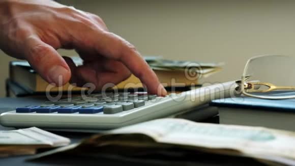 手数计算器和桌子上的钱视频的预览图