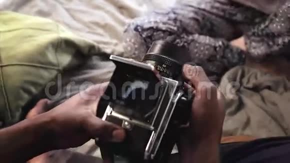 男人在床上用旧的移动胶卷照相录像机中女性的视角视频的预览图