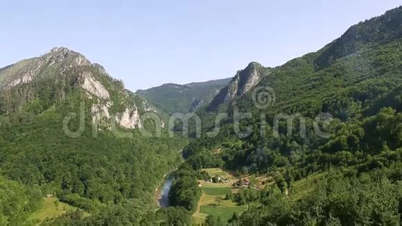 塔拉峡谷大桥杜德维卡以上塔拉河黑山乡村风景中的寂寞房子塔拉的绿色景观视频的预览图