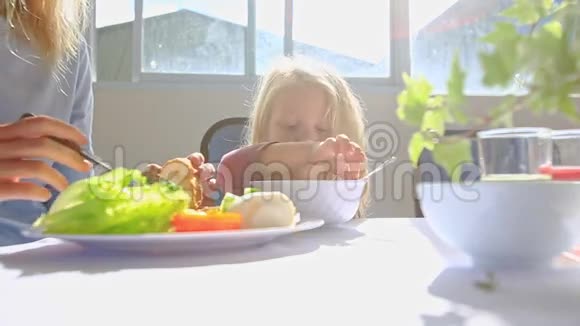 桌上的大碗里放着勺子的小金发女孩视频的预览图