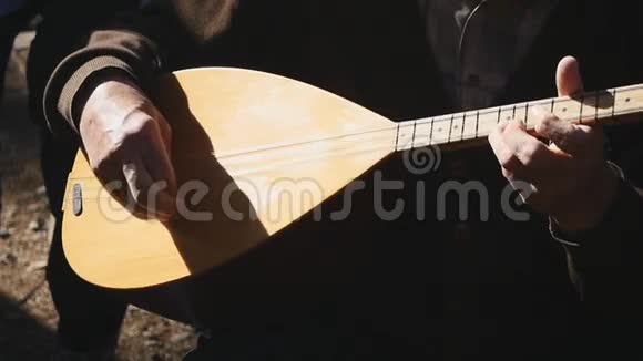 男人的双手演奏古老的老式琵琶弦乐器视频的预览图