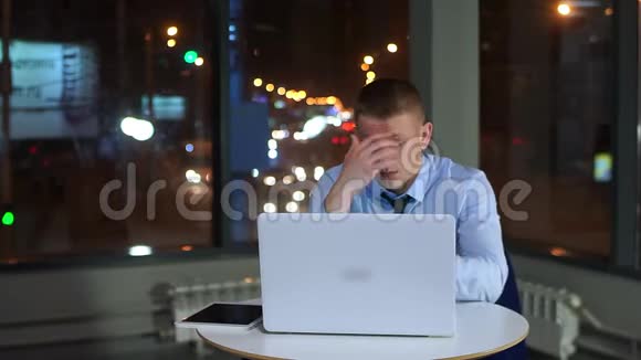 疲惫的商人深夜工作办公室里拿着笔记本电脑视频的预览图