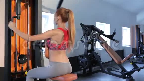 女子倒坐在健身中心健身机的长椅上视频的预览图