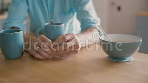 一个男人的手在厨房的桌子上玩他的结婚戒指慢动作视频的预览图