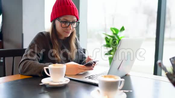 在咖啡馆里工作和喝咖啡的漂亮年轻女人视频的预览图