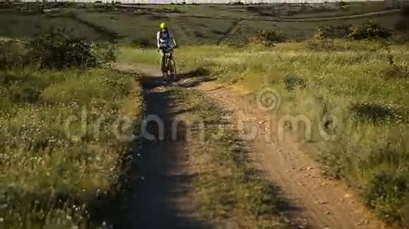骑着山地车在山路上骑着的女自行车视频的预览图