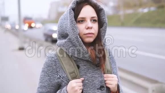 一个穿灰色外套的年轻女子视频的预览图