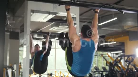 青年运动员在健身房做拉杠腹部运动视频的预览图