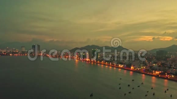 Flycam展示傍晚的城市和日落的海洋海湾视频的预览图
