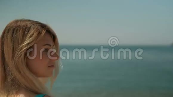 夏天年轻漂亮的女人站在海滩上她钦佩无边无际的壮丽海洋回首往事视频的预览图