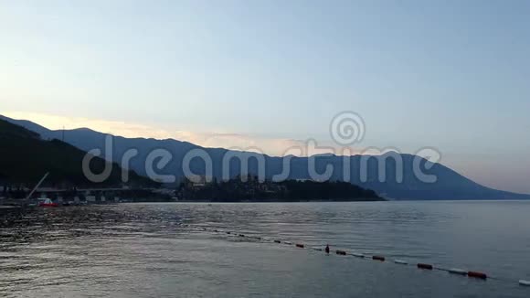 黑山布德瓦市的海滩早上可观赏海滨和海滨山上的蓝色薄雾和海浪直到视频的预览图