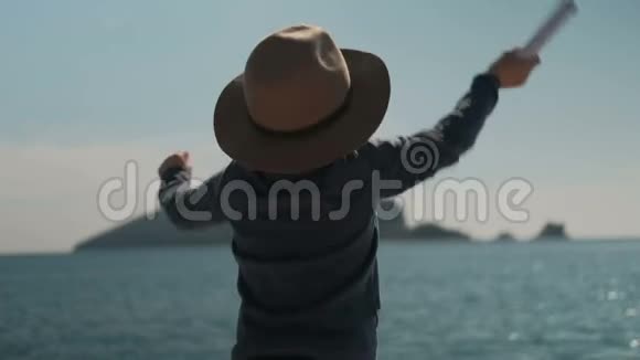 小男孩积极地挥动双手从海里呼唤他的父母视频的预览图