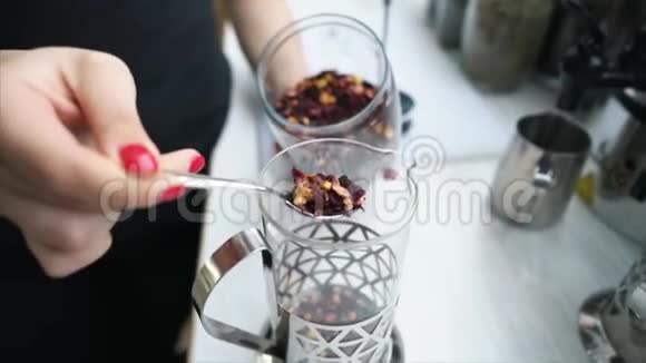 将干茶叶倒入玻璃容器中视频的预览图