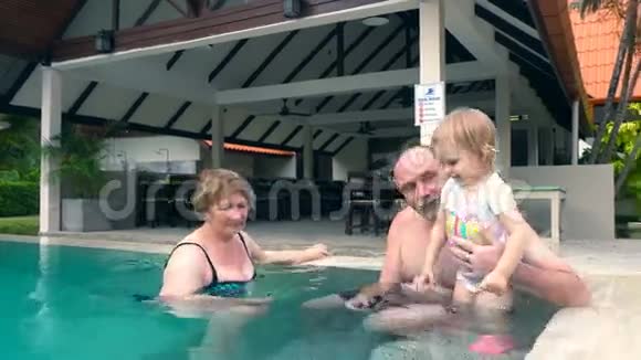 祖父母和孙女在游泳池里玩视频的预览图